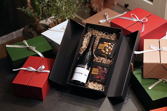 Double Door gift boxes with ribbons, containing a bottle and chocolate