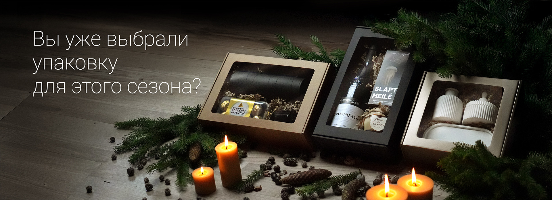 Три элегантно упакованные подарочные коробки со свечами и сосновыми украшениями, с текстом: «Вы уже выбрали упаковку для этого сезона?»